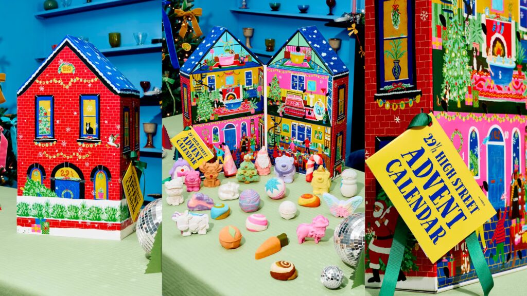 The Lush 29½ High Street Advent Calendar 2026: two illustrated house-shaped calendars with the bath bombs and bubble bars laid out in front of them
