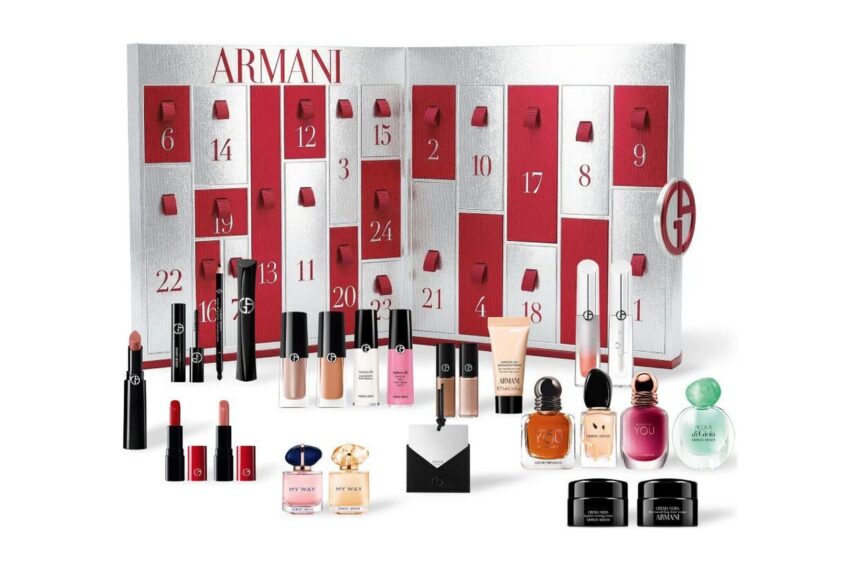The Armani Advent Calendar 2026 opened flat to show its red and silver numbered drawers, with the lipsticks, mascaras, eye tints, fragrance minis, Crema Nera jars and black mirror laid out in front
