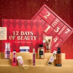 The Bath & Body Works 12 Days of Beauty advent calendar 2026 with its twelve products, from hand creams to a cologne mist, lined up in front of the red box
