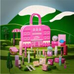 The Benefit Hotel Beneville Advent Calendar 2026, a pink hotel-shaped case on a green hillside set, surrounded by its mascaras, blushes and brow products