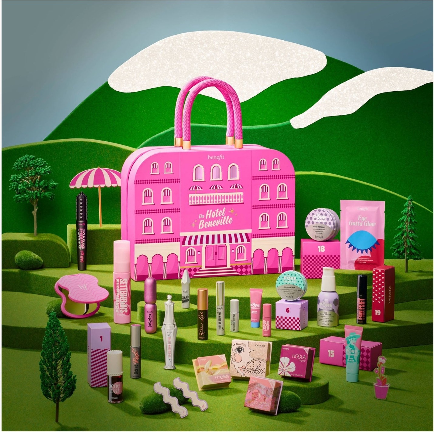 The Benefit Hotel Beneville Advent Calendar 2026, a pink hotel-shaped case on a green hillside set, surrounded by its mascaras, blushes and brow products