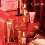 The Charlotte Tilbury advent calendar chest with its drawers open, the Pillow Talk makeup bag on top and products arranged in front