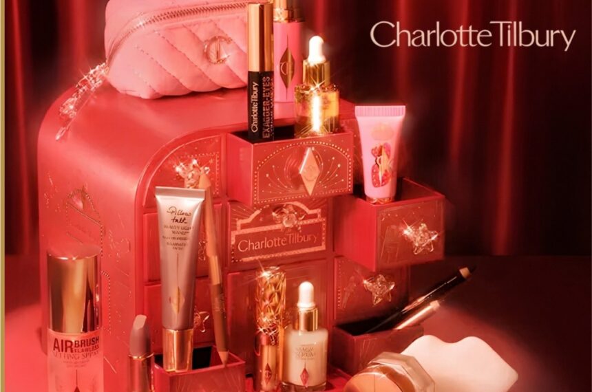The Charlotte Tilbury advent calendar chest with its drawers open, the Pillow Talk makeup bag on top and products arranged in front