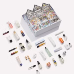 The Liberty Beauty Advent Calendar 2026 in its Clym Evernden illustrated house-shaped box, open with the products displayed in front