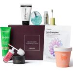 The LOOKFANTASTIC New Season Edit box with its eight products in front: Weleda Skin Food, an Anua mist, The INKEY List cleansing balm, a KIKO Milano lip cream, a Made by Mitchell highlighter, a Sam McKnight mask, an Umberto Giannini scalp scrub and a Dr. Jart+ mask