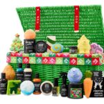 The Lush Advent Calendar 2026, an open green wicker hamper, with its bath bombs, shower gels, candle, perfume and socks arranged in front