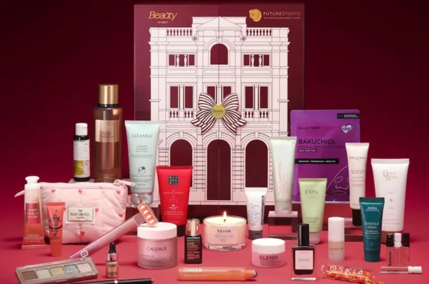 The Next Beauty Advent Calendar 2026 box with all 30 products arranged in front of it on a burgundy background
