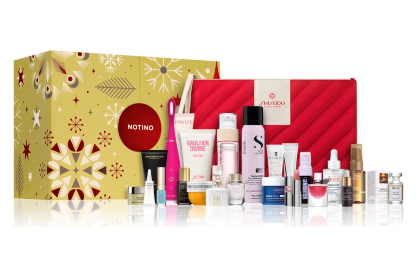 The gold Notino Exclusive Advent Calendar 2026 box with its 25 beauty products and a red pouch lined up in front