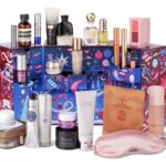 The Space NK 12 Days of Luxury Advent Calendar 2026, open, with its products arranged in front of the illustrated box