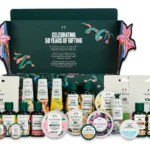 The Body Shop Classic Beauty Advent Calendar 2026 green box open with all 24 travel-size body butters, shower gels, hand creams and sheet masks arranged in front