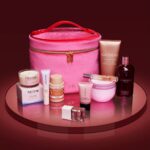 The Tili Luxe Beauty Edit 2026 beauty gift set arranged on a mirrored stand with its pink velvet vanity case