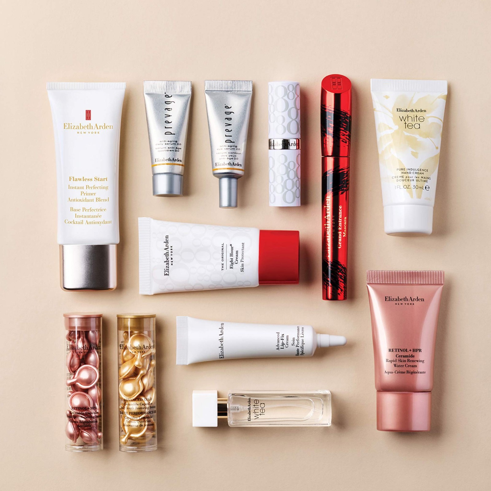 A flatlay of everything in the Elizabeth Arden advent calendar 2026: ceramide capsules, Eight Hour Cream, PREVAGE serums, White Tea fragrance and hand cream, primer and mascara