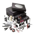 The 24 Days of M·A·C Icons Advent Calendar 2026, a black glittering box of stacked drawers with a mirrored lid, with its lipsticks, lip pencils, mascaras, eyeshadows, lashes and skincare minis set out in front